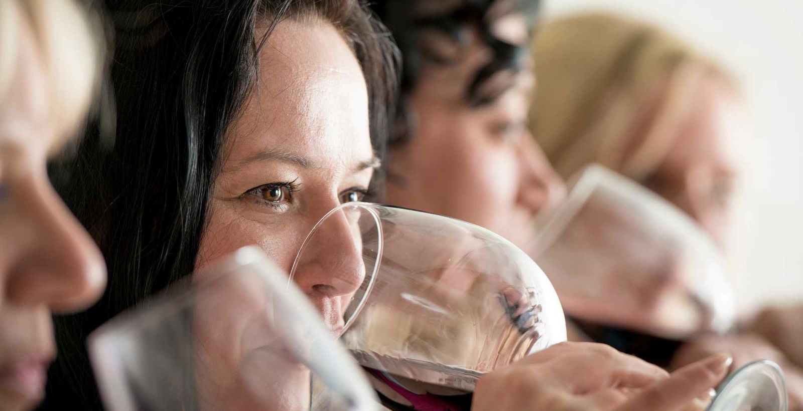 A close-up on a woman drinking red wine.