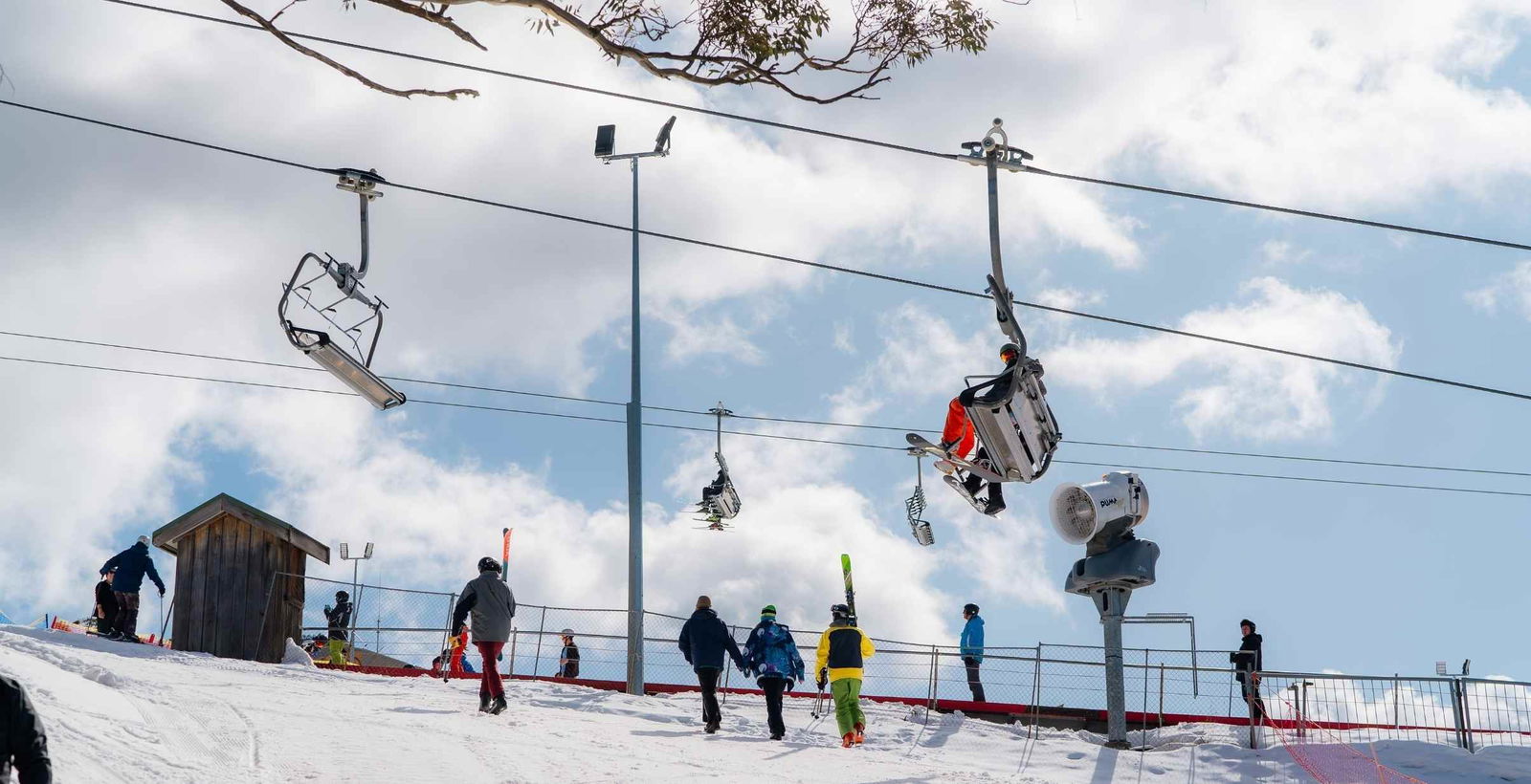 A bus scene of people walking around Mt Buller Ski resort with skilift.
