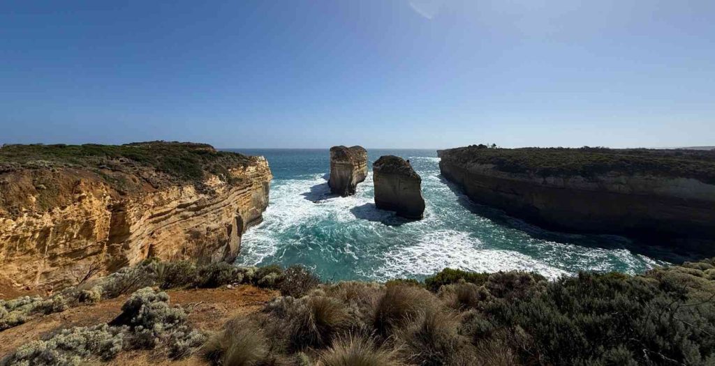 Two rock formations jutting high out of the ocean at Loch Ard Gorge on a clear sunny day.